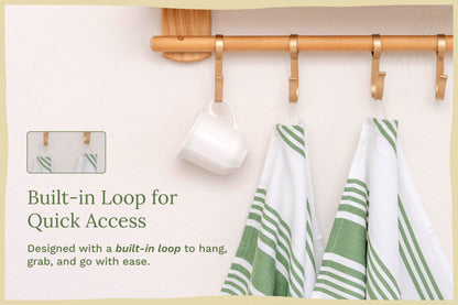 Pair of white kitchen towels with green stripes hanging from a wooden rod