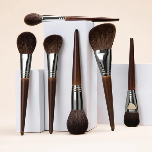 Goat hair makeup brushes set showing several full and tapered heads with brown wooden handles