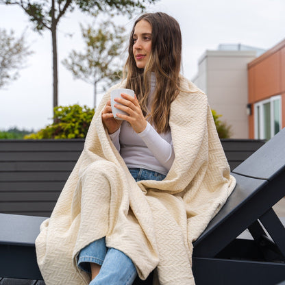 Herringbone cotton blanket, ivory, draped and folded with chevron knit texture