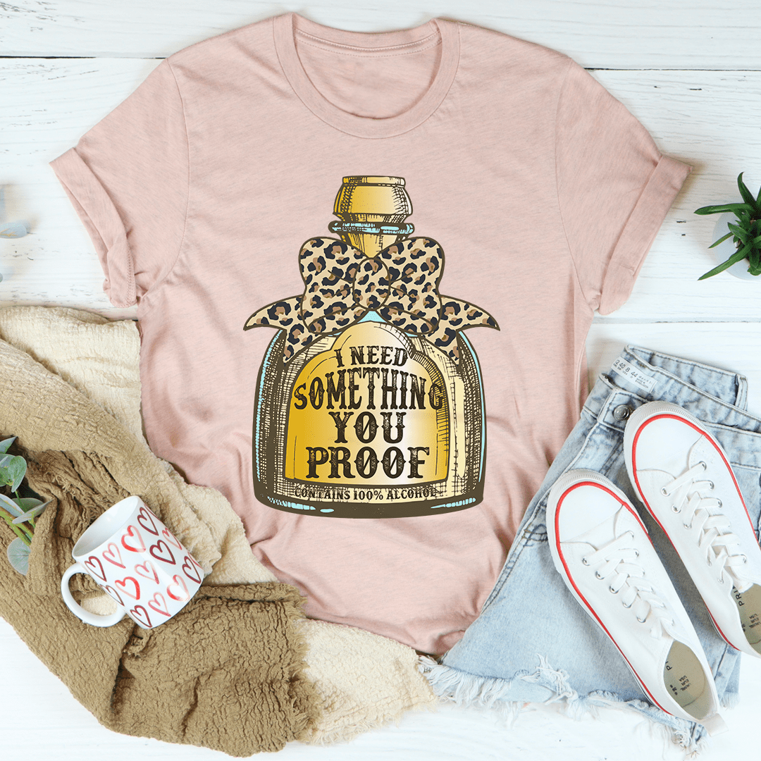 Peach T-shirt with leopard bottle graphic and I NEED SOMETHING YOU PROOF text.