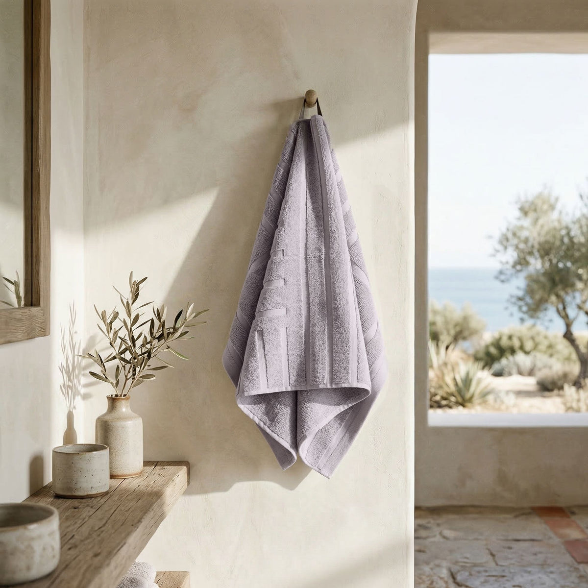Lilac bath towel folded and hanging, with a neatly finished edge.