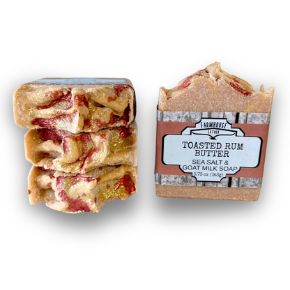 Goat milk soap bar with red streaks, in labeled paper wrap