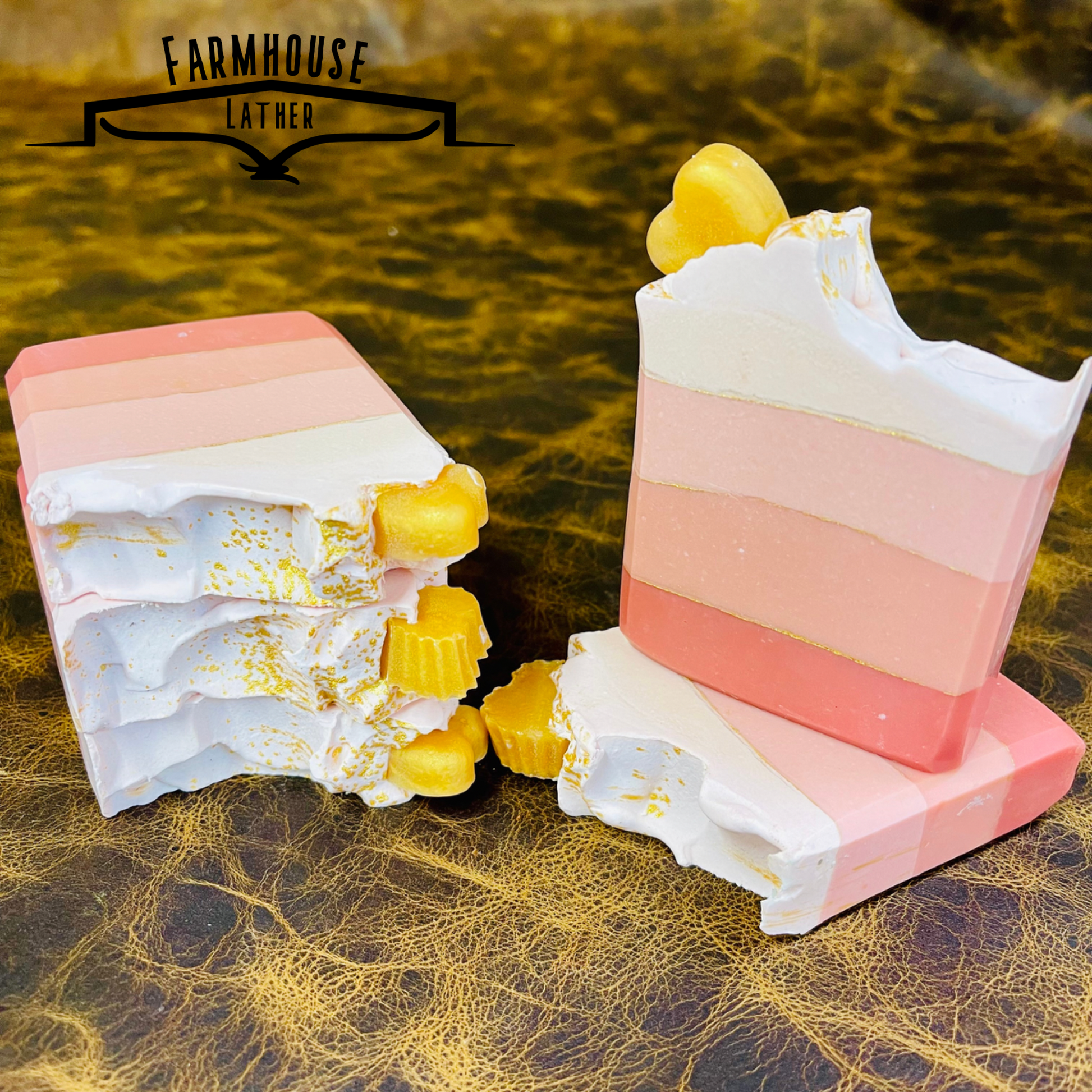 Layered pink soap bars with white swirls and yellow cubes, two pieces
