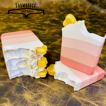 Layered pink soap bars with white swirls and yellow cubes, two pieces
