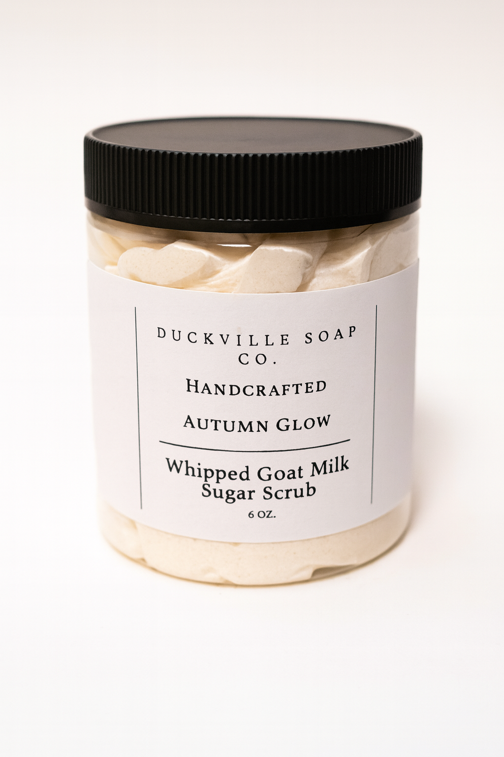 Whipped goat milk sugar scrub jar, Autumn Glow label, black lid, beige flakes