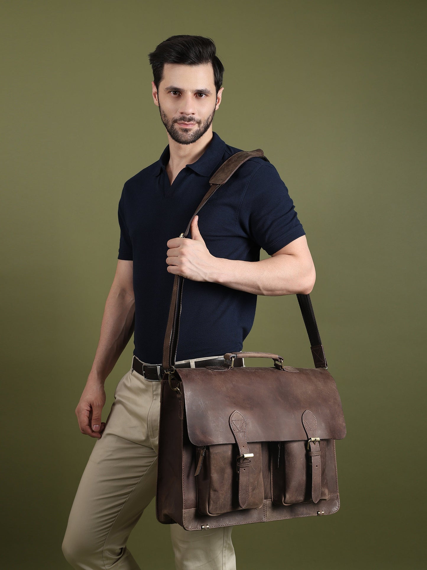 Brown buffalo leather messenger bag worn across the body with flap and front pocket details.