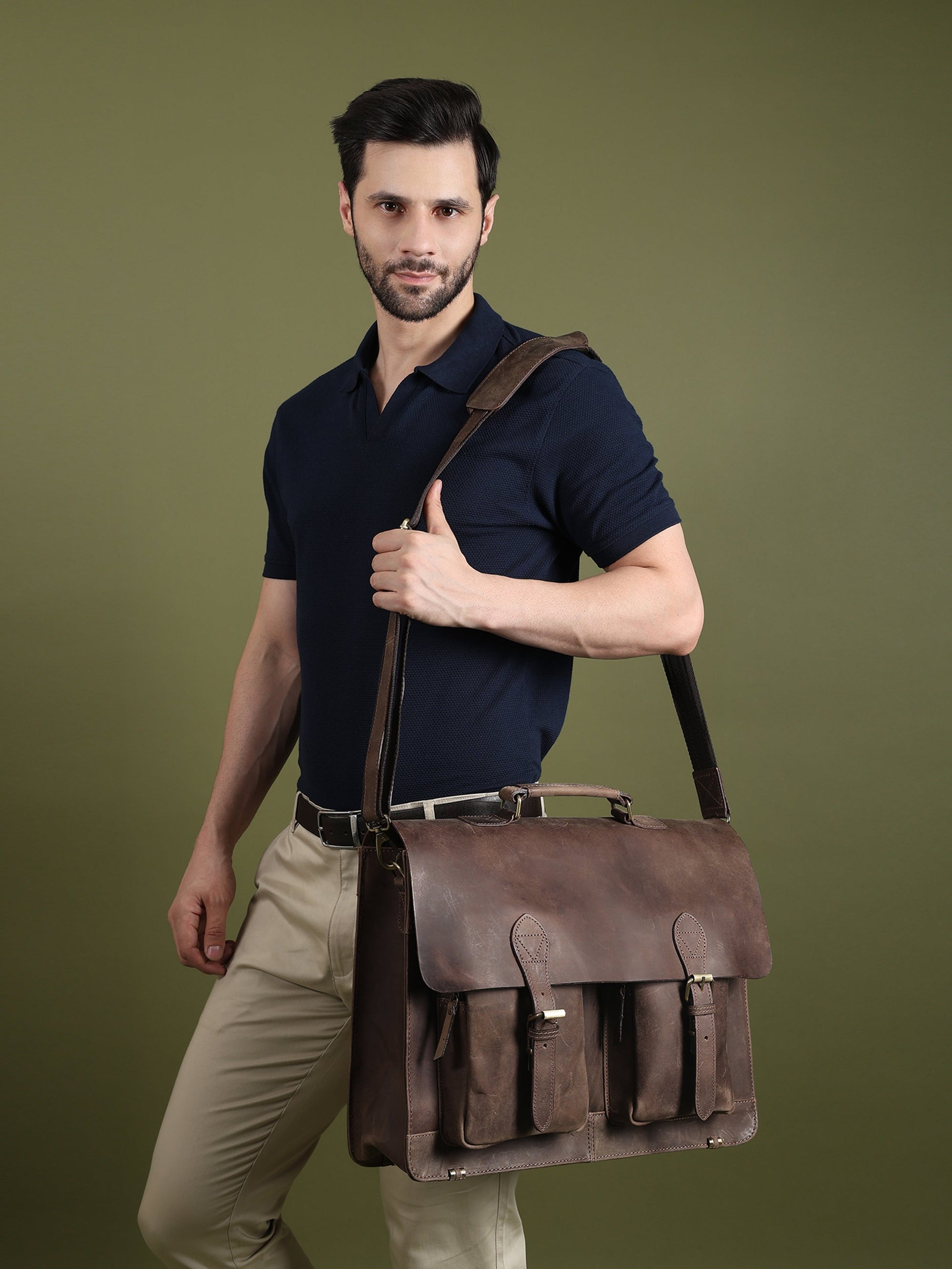 Brown buffalo leather messenger bag worn across the body with flap and front pocket details.