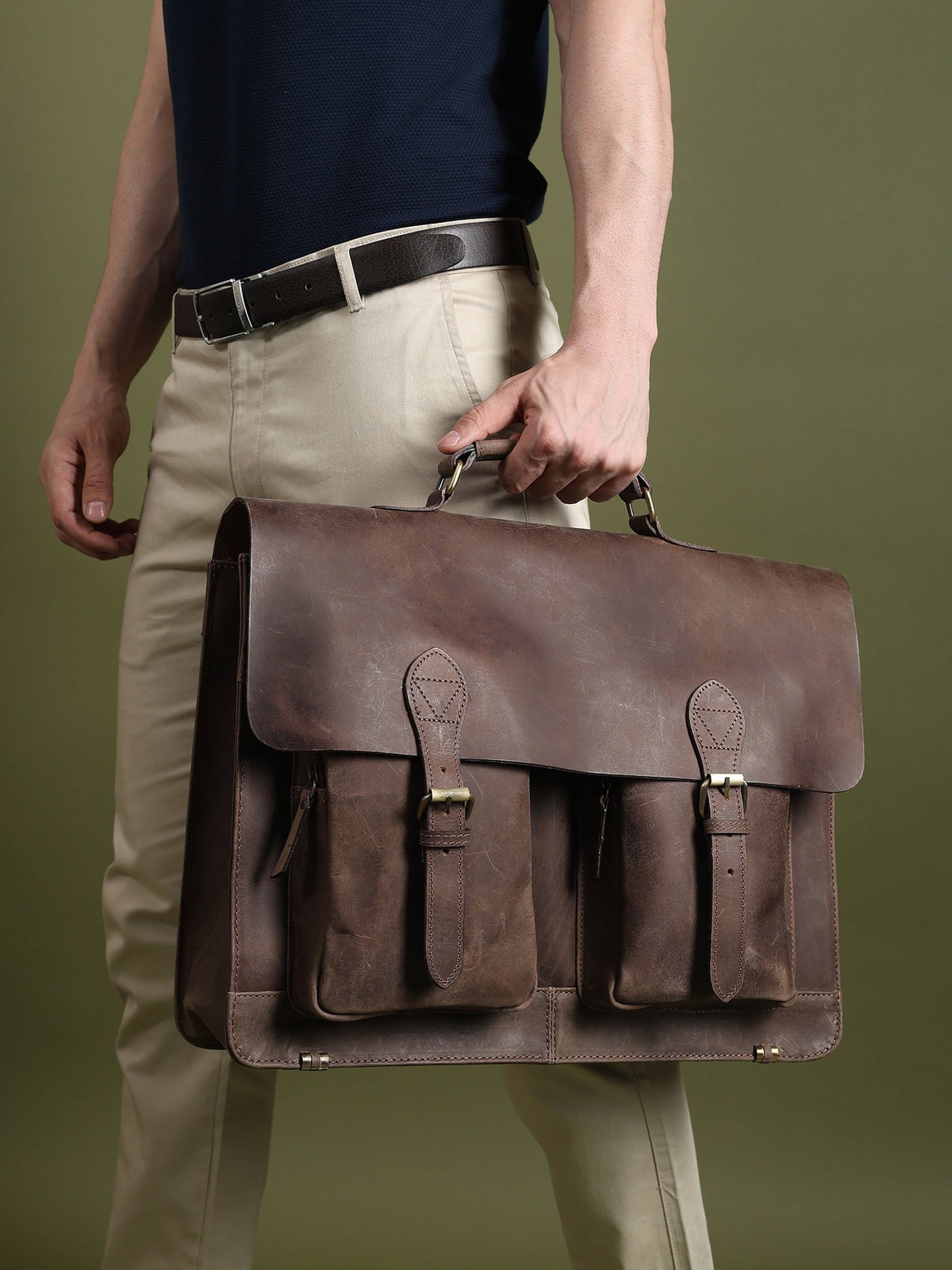 Brown buffalo leather messenger bag with flap closure and front pocket straps on shoulder.