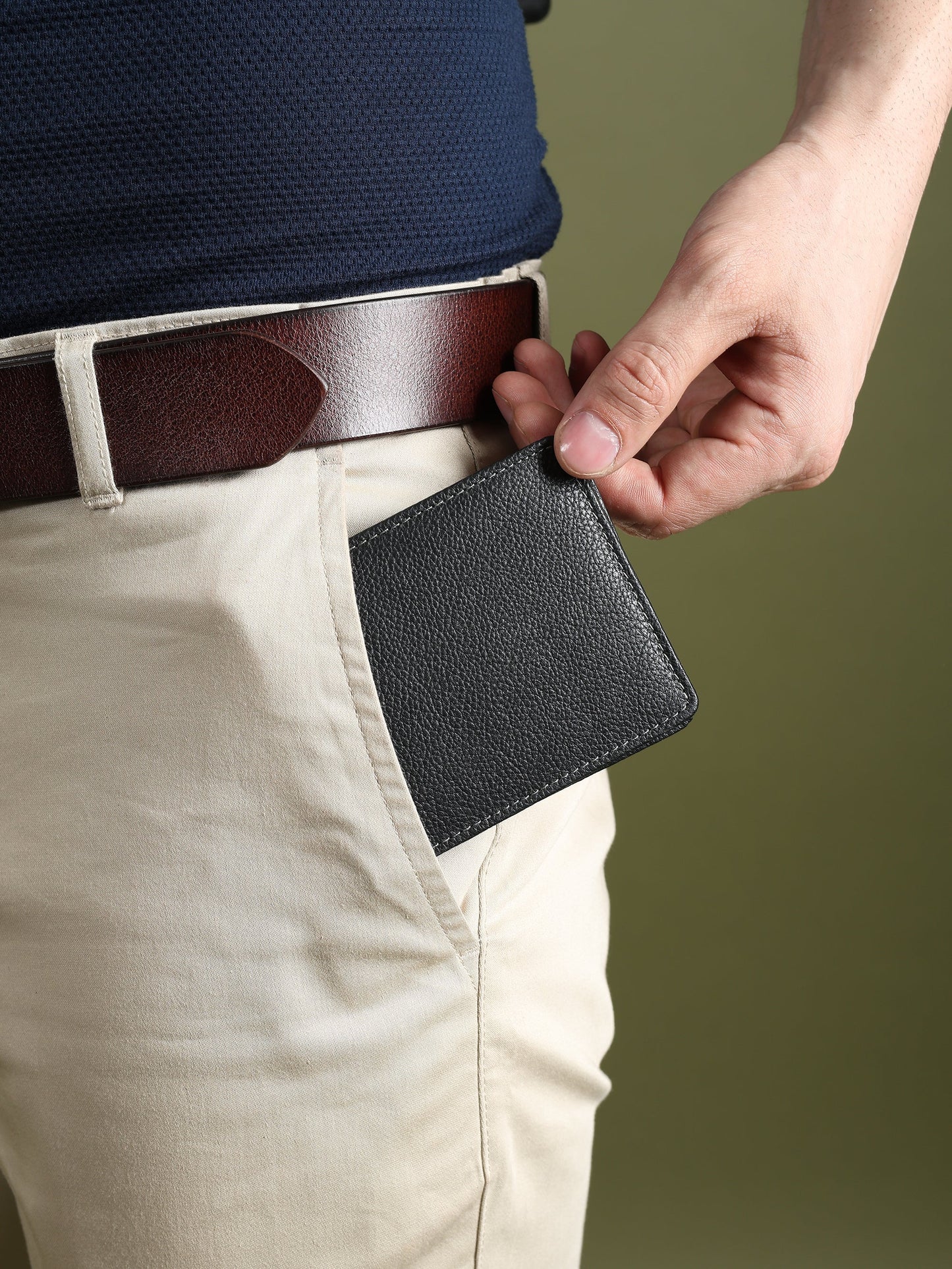 Black textured leather men’s wallet clipped near belt loop, compact bi-fold
