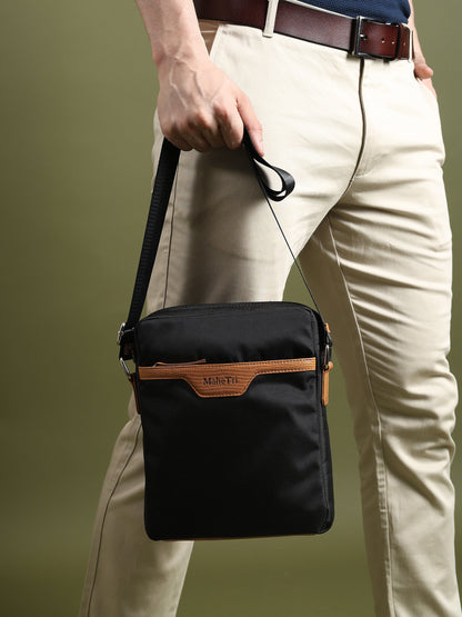 Black canvas side messenger bag with tan trim worn at hip with crossbody strap