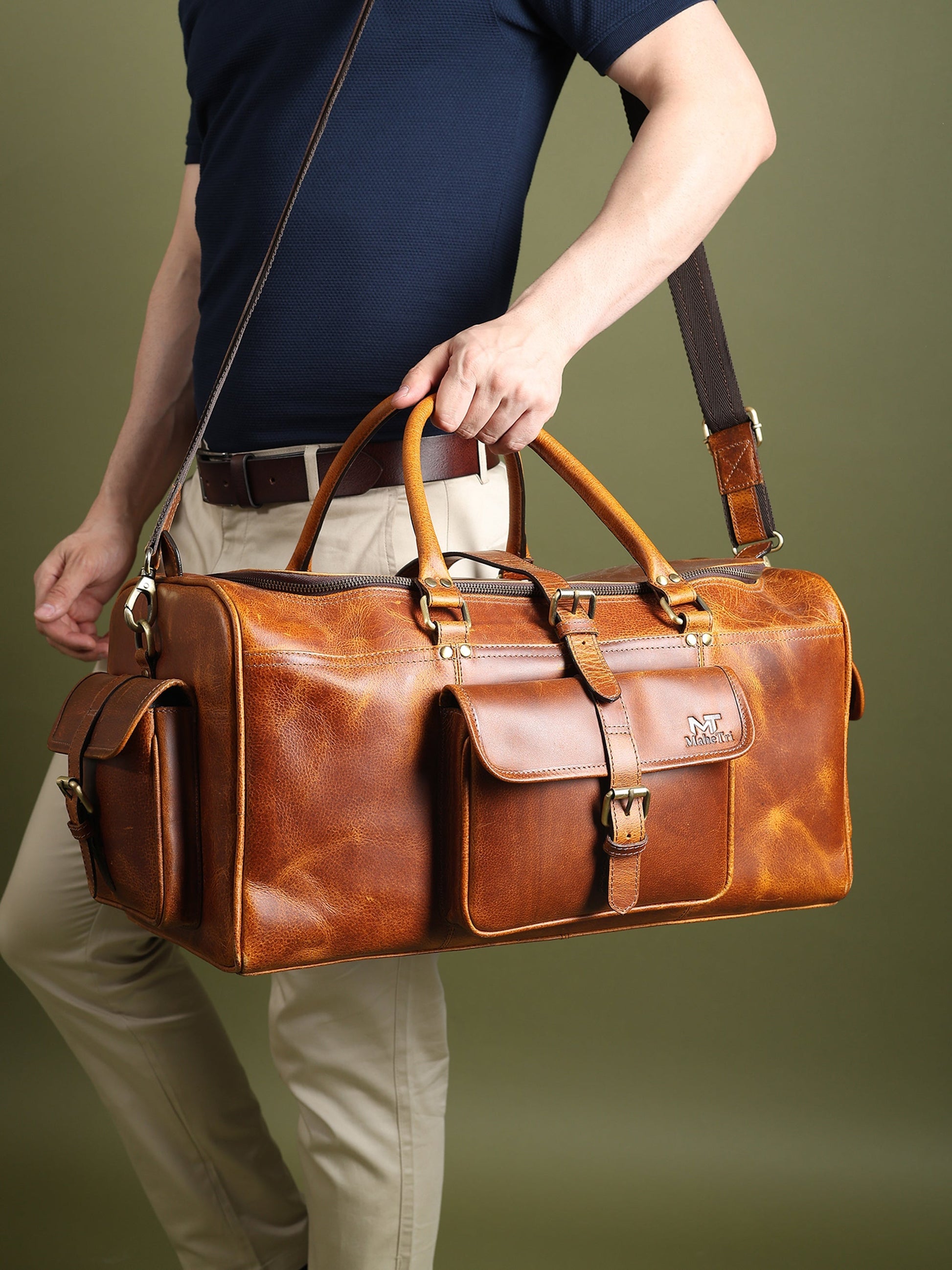 Berlin leather weekender duffle bag in brown leather with crossbody strap and front buckle organizer