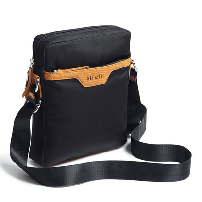 Black canvas side messenger bag with tan trim, front zip pocket, and adjustable strap