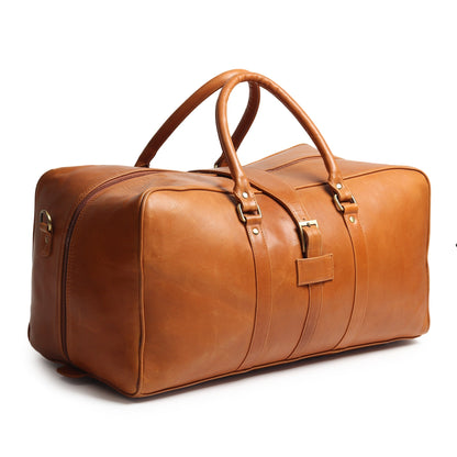 Tan leather duffle bag with top handles and front buckle strap, angled view