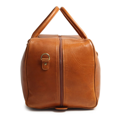 Tan compact leather duffle bag with top handle and front strap detail, side view