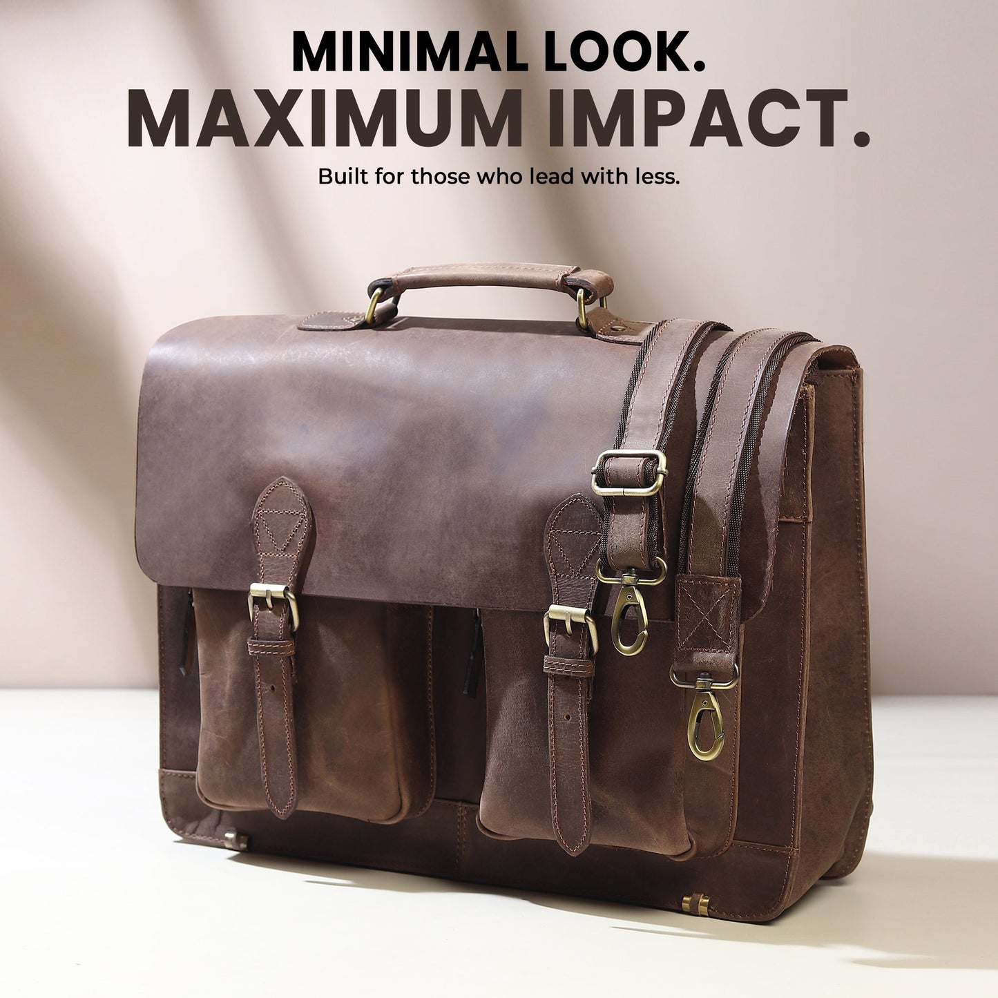 Brown buffalo leather messenger bag with top handle, front buckle pockets, and side strap.