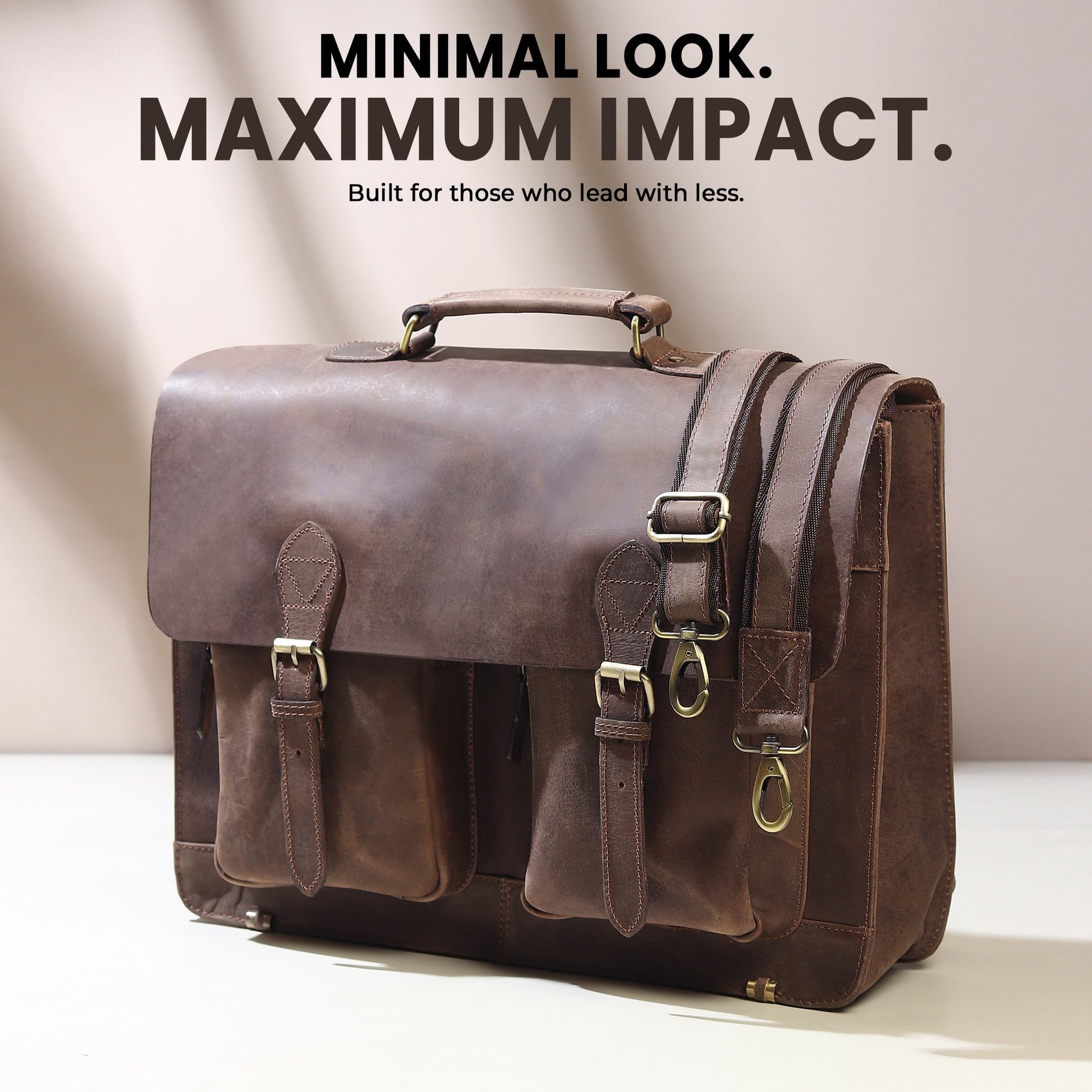Brown buffalo leather messenger bag with top handle, front buckle pockets, and side strap.