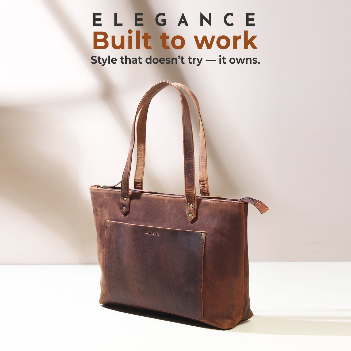 Large brown leather tote bag with top handles and front slip pocket