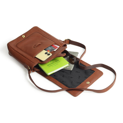 Brown leather crossbody bag open, showing cards and documents inside front compartment