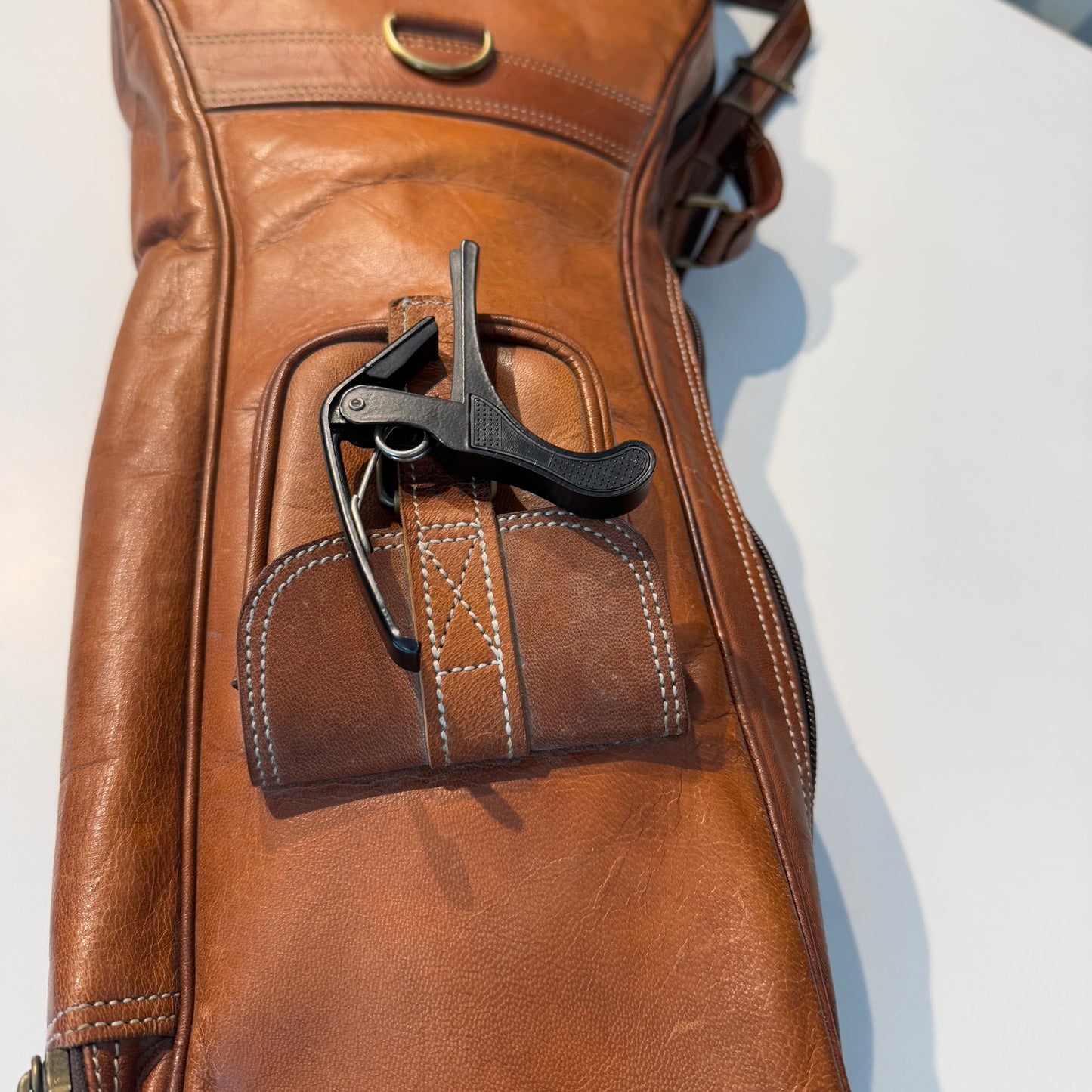 Brown leather guitar case with molded handle pocket and tool holder