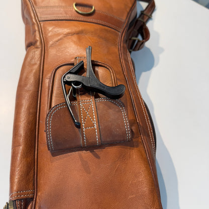 Brown leather guitar case with molded handle pocket and tool holder