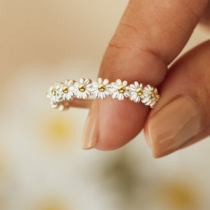 Rotatable daisy flower ring band with small white blossoms and gold accents