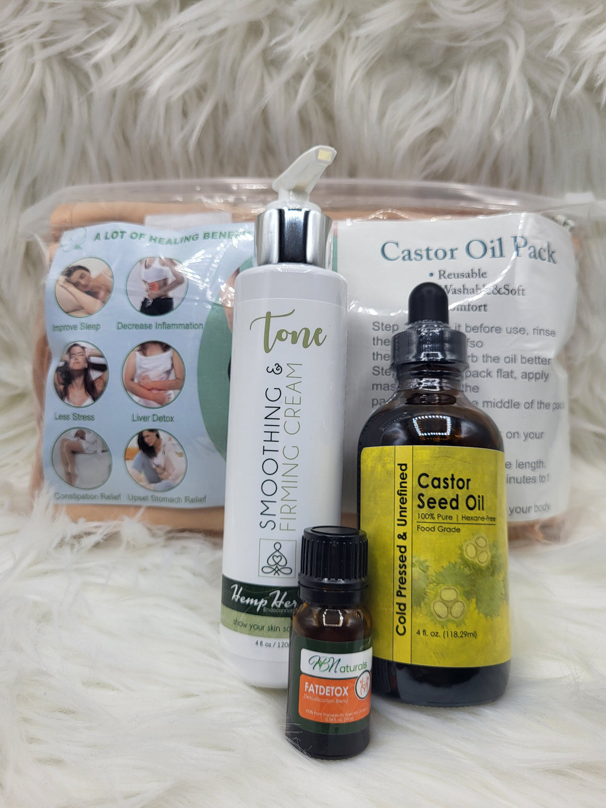 Castor oil bottle, small dropper oil bottle, and smoothing cream pump on soft white fur