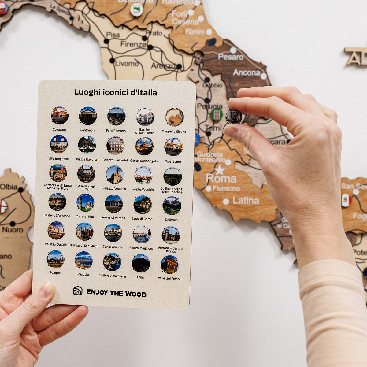 Round Italy landmarks pin placed on a wooden map, featuring a small building scene