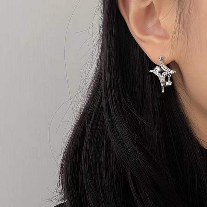 Silver rhinestone star cross earrings on ear, small stud and charm
