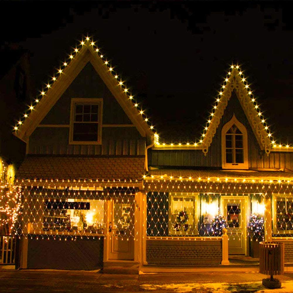 Solar fairy lights netting with warm white glow along a house facade