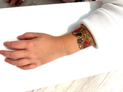 Kids temporary tattoo band tattoo on wrist: colorful Halloween skull and pumpkin