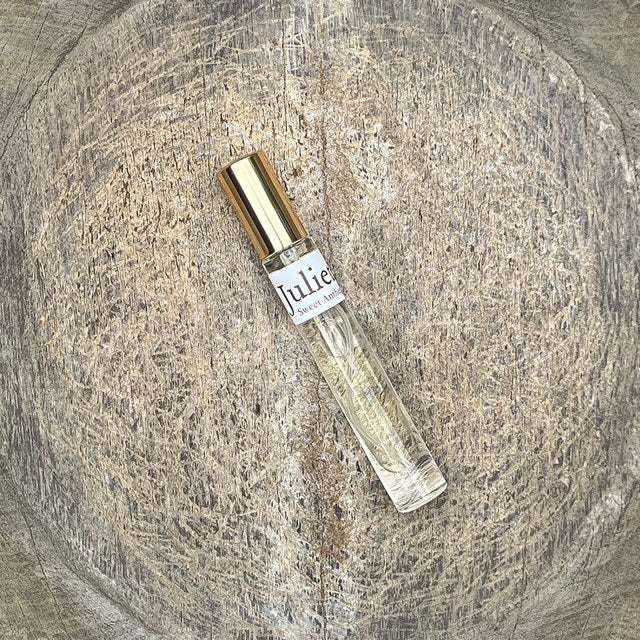 Eau de parfum bottle with clear glass and gold cap, angled view