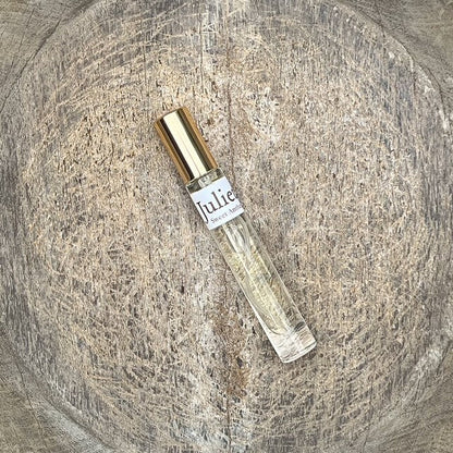 Eau de parfum bottle with clear glass and gold cap, angled view