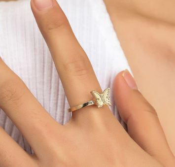 Gold fidget spinner ring with small butterfly charm on finger
