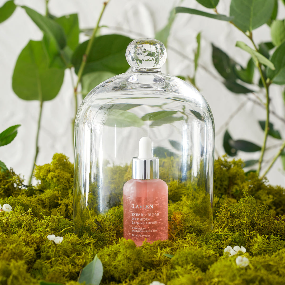 Calming ampoule dropper bottle with amber serum under glass dome on moss