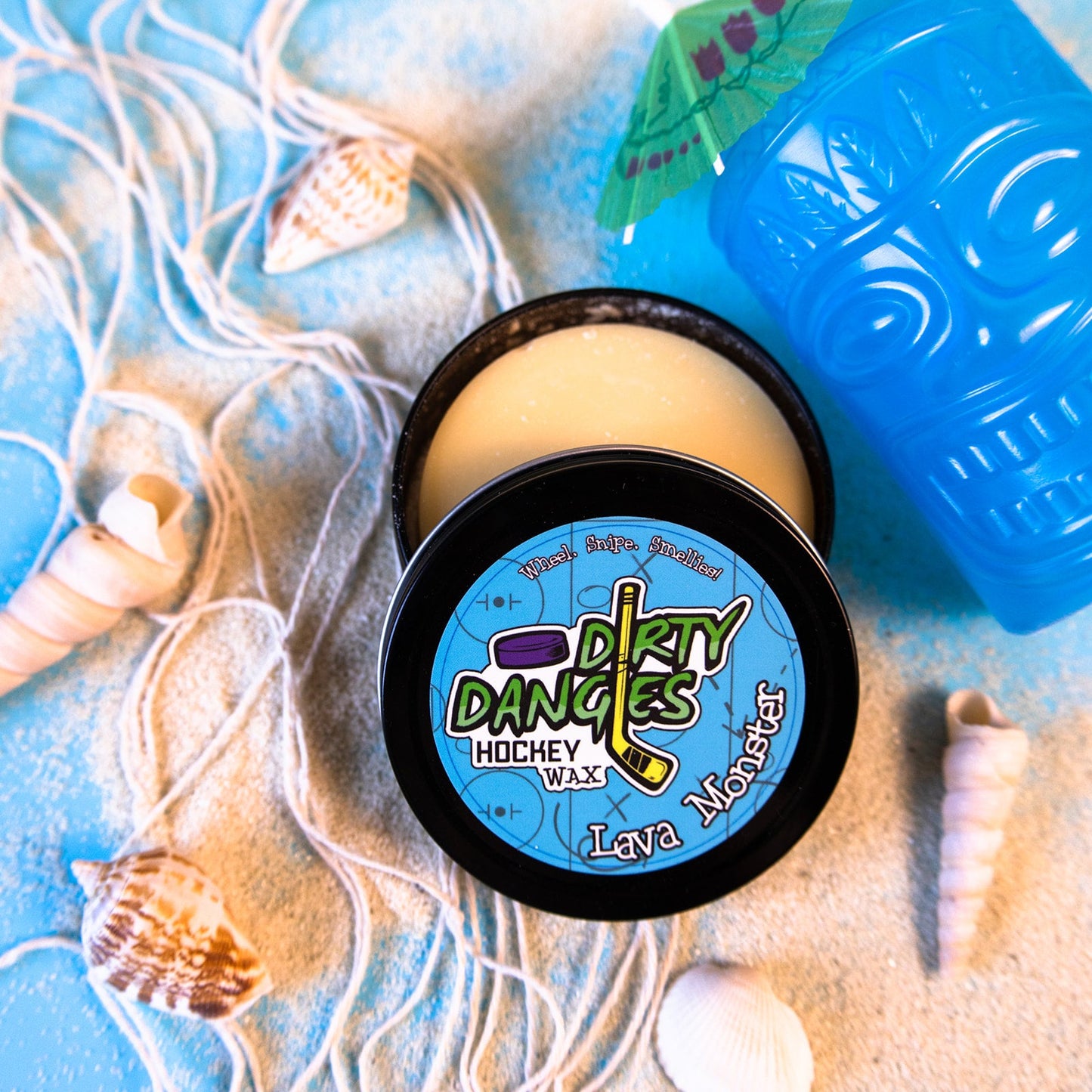 Round hockey wax tin with pale yellow wax and black lid with Dirty Dangles graphic