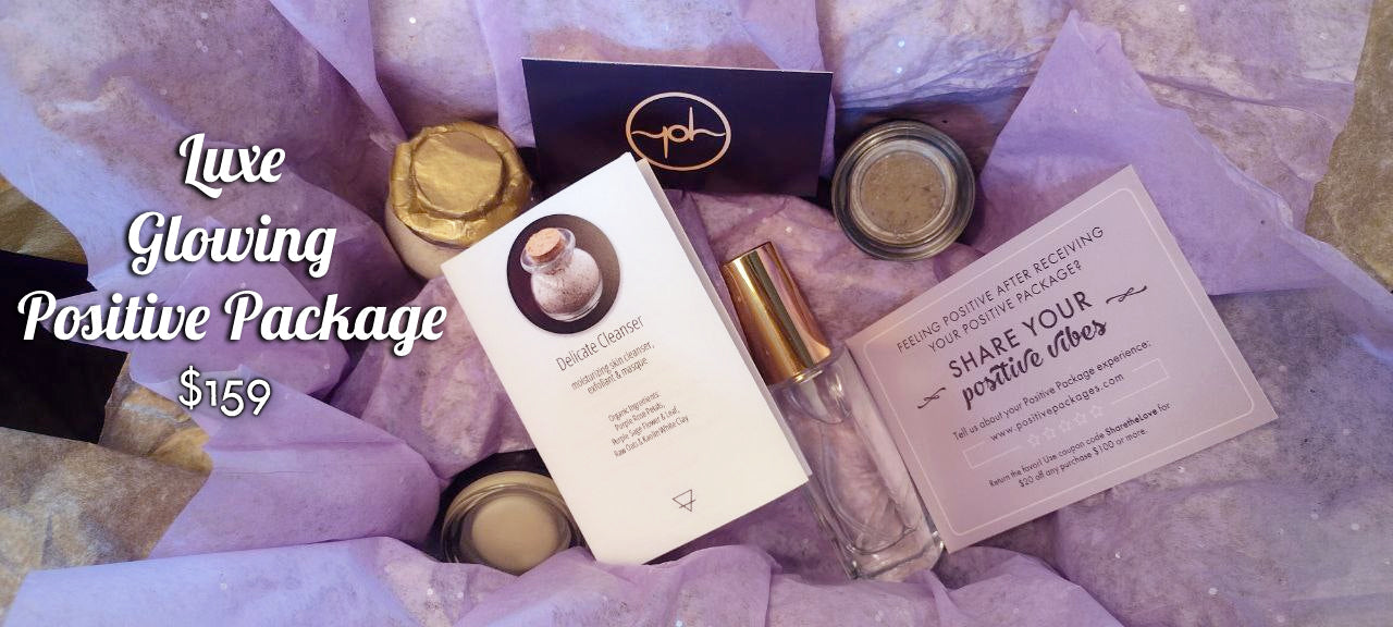 Skincare gift set with gold-capped tubes, jars, and two cards on tissue