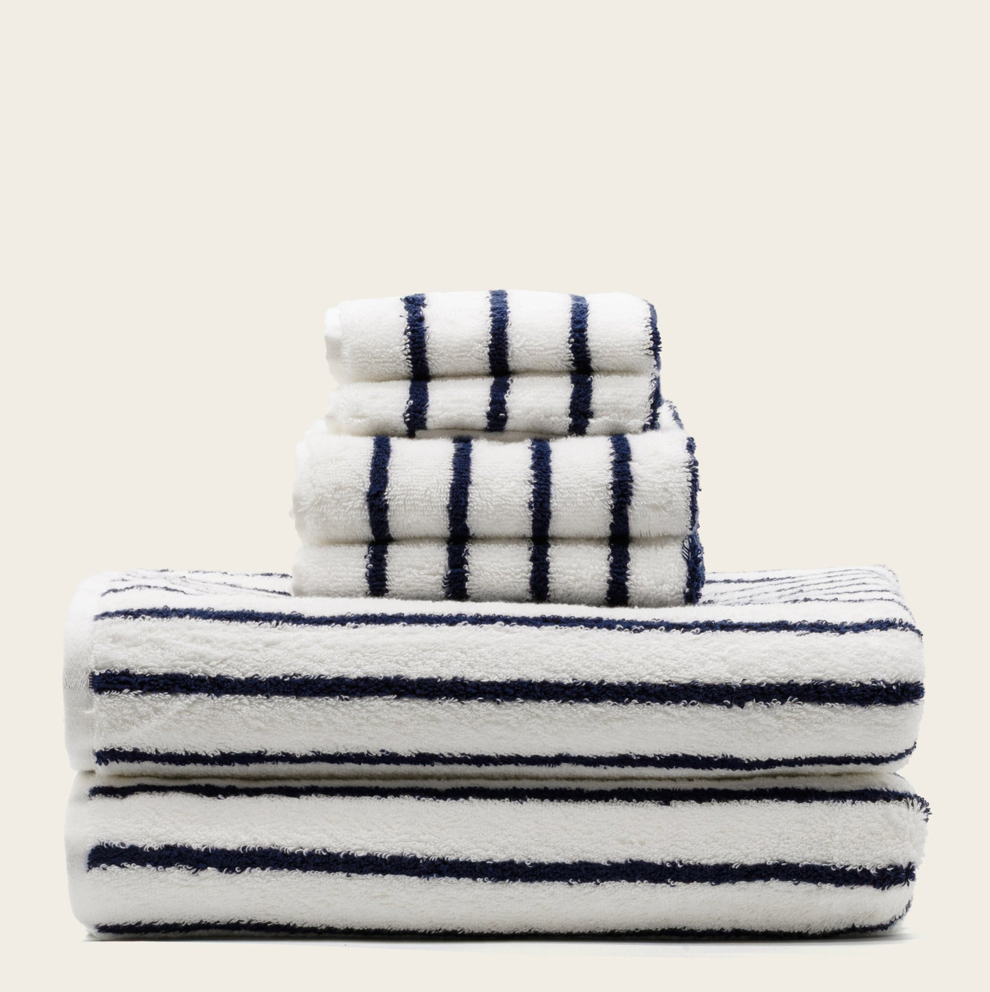 White towels with navy blue stripes, folded bath towel and washcloth set stack.