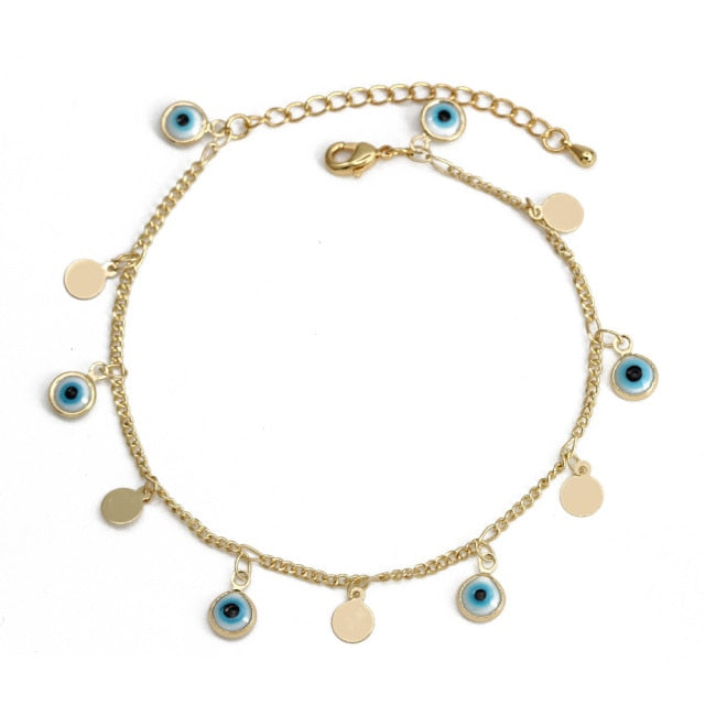 Charm bracelet with gold chain, blue evil-eye beads, and round heart dangles
