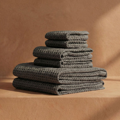 Charcoal waffle cotton towels stacked, textured grid weave with folded edges