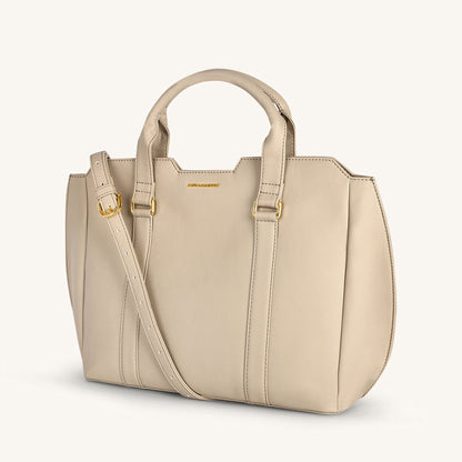 Light taupe crossbody bag with top handle and adjustable strap, stitched panels