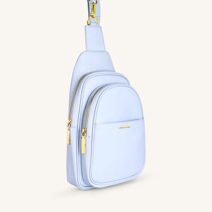 Ice blue fanny bag side view with gold zipper details and strap