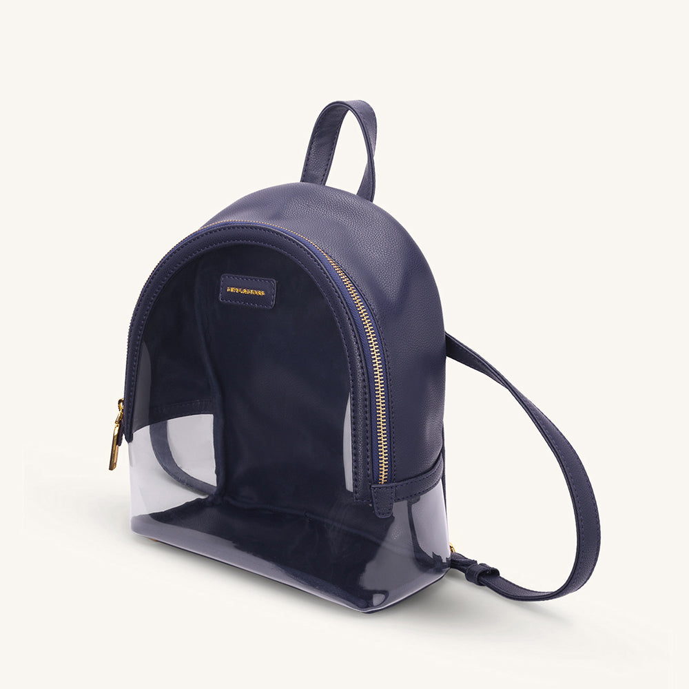 Navy mini clear backpack with gold zipper, curved shoulder strap, and front panel