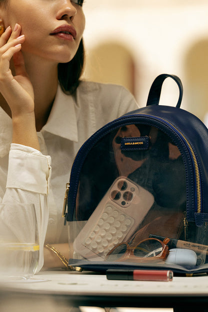 Navy clear backpack open, showing transparent pocket with small items inside