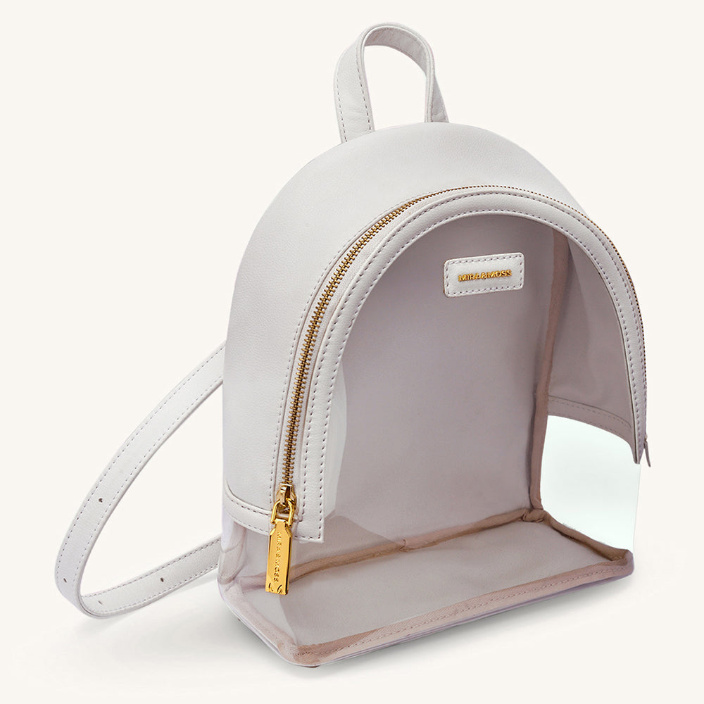 Ivory clear-front mini backpack with gold zipper and curved front pocket