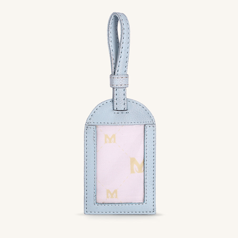Ice blue travel tag with hanging loop and gold M letters in front window panel