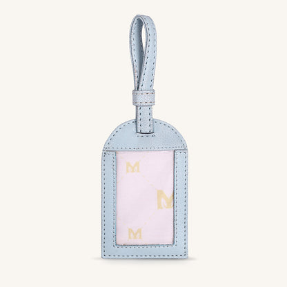 Ice blue travel tag with hanging loop and gold M letters in front window panel