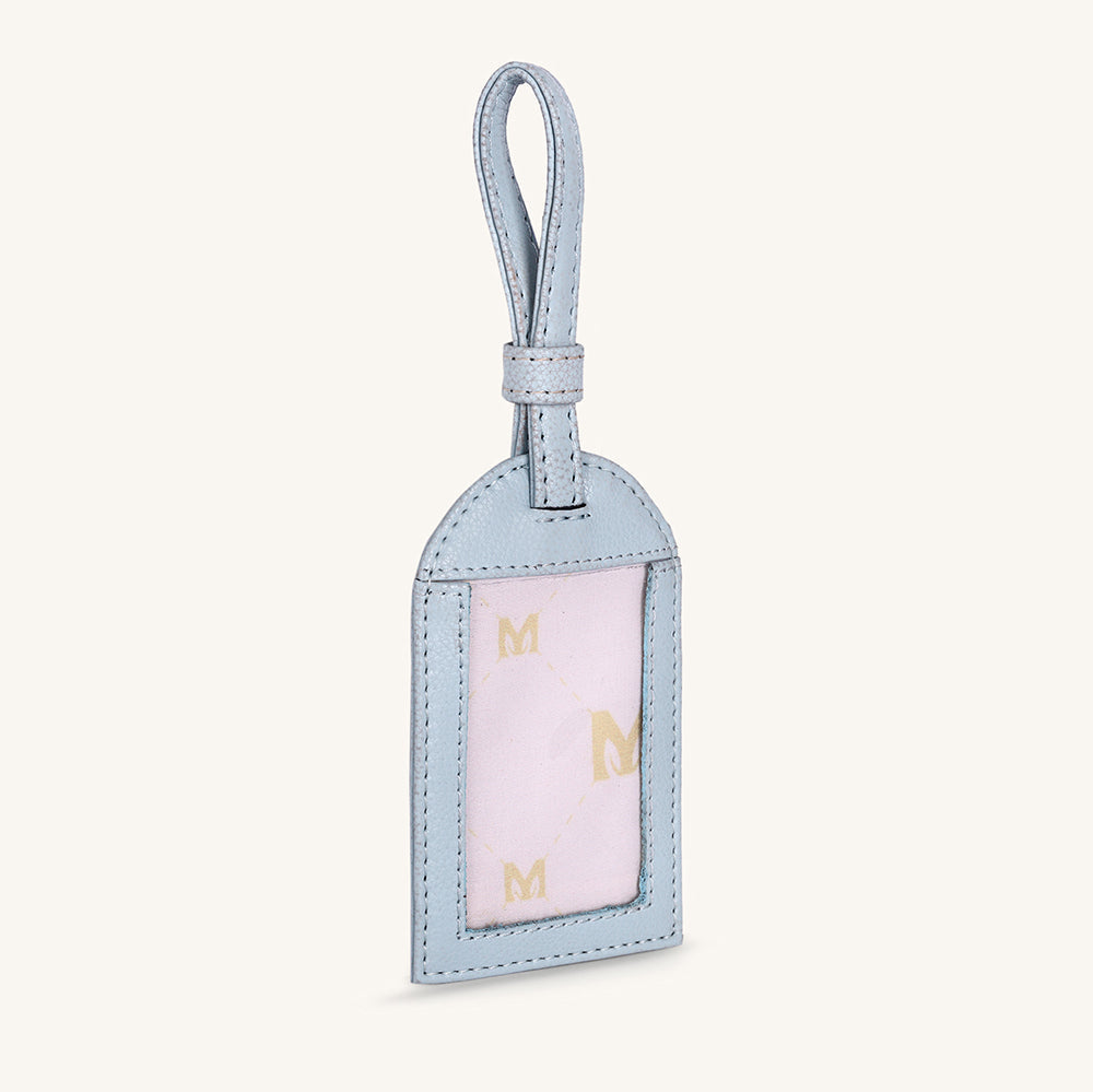 Ice blue travel tag with hanging loop and clear front window showing gold M pattern