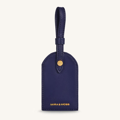 Alexis travel tag in dark blue leather with top loop and gold snap, front logo