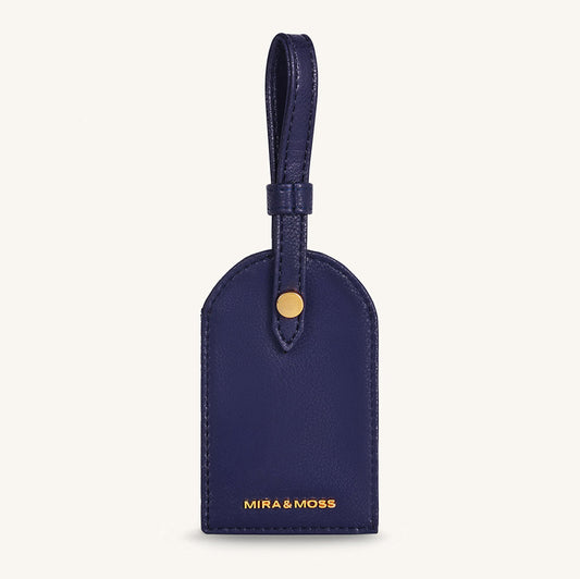 Alexis travel tag in dark blue leather with top loop and gold snap, front logo