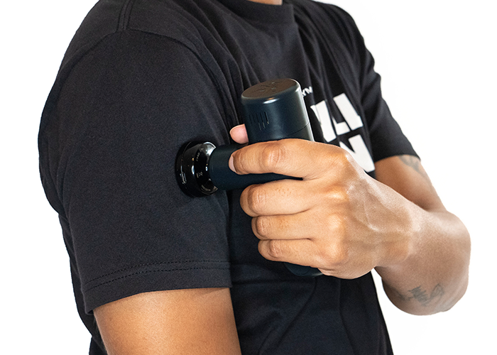 Handheld heated massage head held near arm, black nozzle attachment